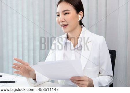 Young Asian women are talking friends and manager through video chats and greeting them with cheerfu