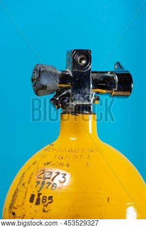 Vintage Yellow Steel Scuba Tank With A J Valve On A Blue Background