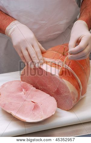 Trabalhando em uma porção de presunto presunto de carne de açougue.