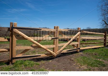 Fresh New Fence And Gate In A Sunny Pasture Under A Blue Sky. Serene, Tranquil Nature Image Of Secur