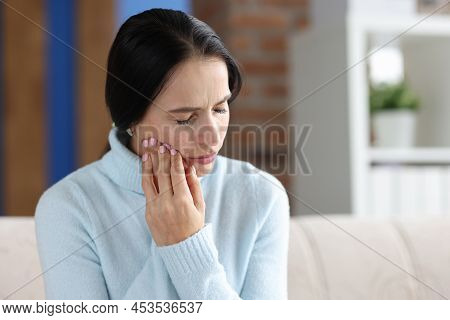 Woman Holding Her Cheek In Area Of Sore Tooth. Diagnosis And Treatment Of Pulpitis Concept