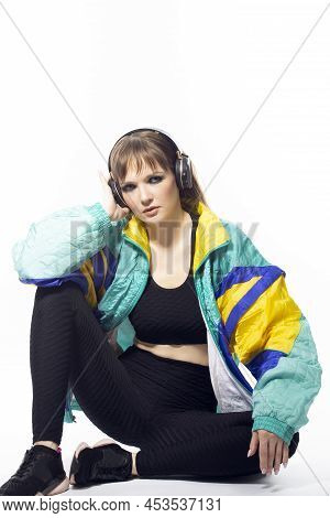 Young Winsome Caucasian Female Athlete Sportwoman In Fitness Sexy Outfit Wearing Wireless Phones Whi
