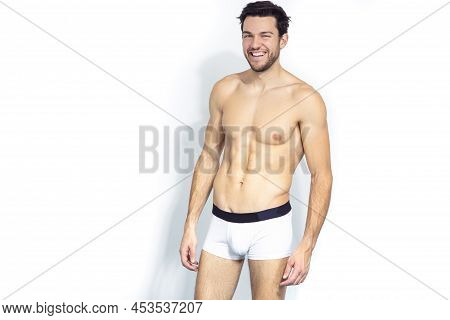 Smiling Positive Sensual Caucasian Handsome Brunet Man Posing In Underware Against White Background.