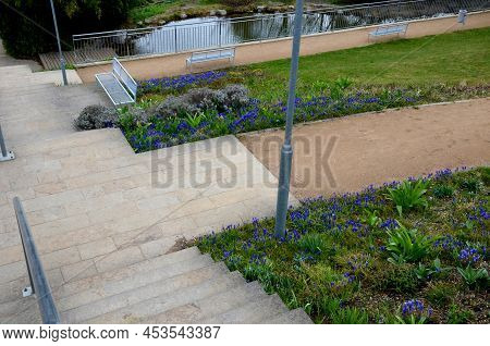 Between The Stairs Is A Waterfall With Stones And Boulders. Artificial Stream With A Waterfall Betwe