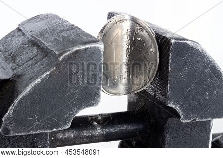 Twisted And Broken Coin One Russian Ruble Clamped In Metal Vice On White Background. Business Proble