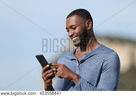 Happy Man With Black Skin Using Smart Phone Outside In The Mountain