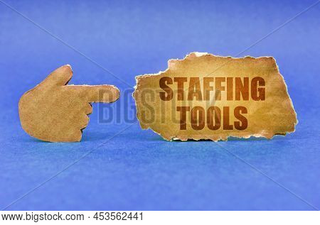 Business Concept. On A Blue Surface, A Cardboard Hand Points To A Sign With The Inscription - Staffi