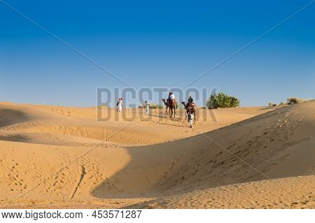 Tourists Riding Camels, Camelus Dromedarius, At Sand Dunes Of Thar Desert. Camel Riding Is A Favouri
