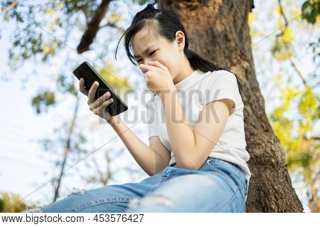 Sad Asian Student Victim Of Cyber Bullying Online Sitting Alone Outdoor At School,teenage Girl Recei