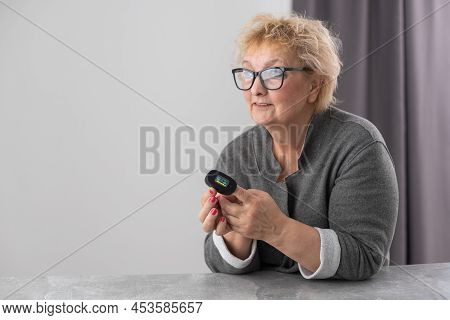 Hand Of Senior Woman With An Attached Pulse Oximeter On Fingertip, Old Elderly Measuring Heart Rate,