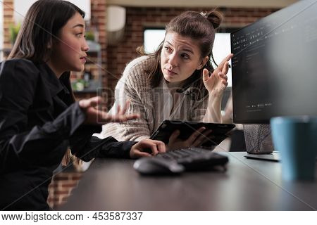 Unsure Asian Programming Expert Asking Colleague About Generated Bug Report File. Blockchain Develop