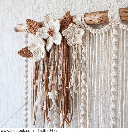 Handmade Macrame Wallhanging. 100% Cotton Wall Decoration With Wooden Stick Hanging On A White Wall.