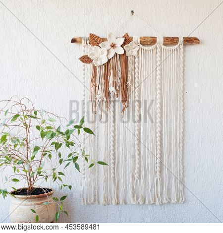 Handmade Macrame Wallhanging. 100% Cotton Wall Decoration With Wooden Stick Hanging On A White Wall.