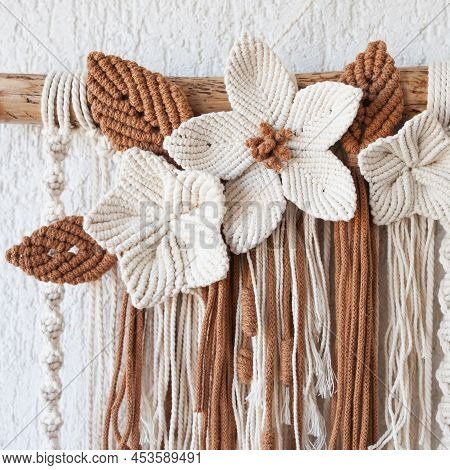 Handmade Macrame Wallhanging. 100% Cotton Wall Decoration With Wooden Stick Hanging On A White Wall.