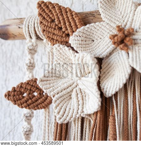 Handmade Macrame Wallhanging. 100% Cotton Wall Decoration With Wooden Stick Hanging On A White Wall.