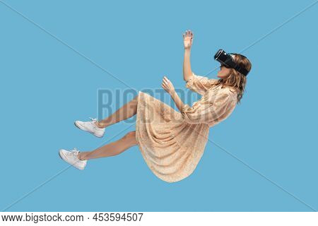 Amazed Surprised Gamer Girl Hovering In Air, Levitating With Virtual Reality Glasses On Head, Playin