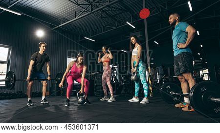 Group Of Young Friends Doing Sports, Training At Gym Indoors, Building Muscles And Srength