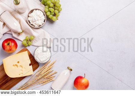 Shavuot Flat Lay With Dairy Products, First Fruits And Wheat On Light Gray Background. Jewish Shavuo