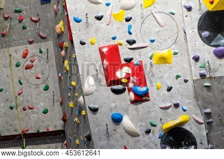 Artificial Rock Climbing Wall With Various Colored Grips.
