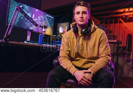 Smiling Pro Gamer Sitting By Equipment For Gaming And Live Streaming At Home