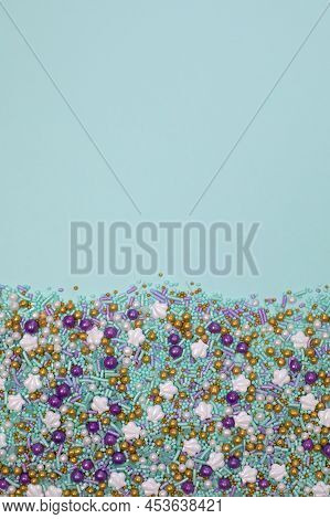 Various Purple, Gold, White And Light Blue Beads And Shells Flat Lay On Tropical Blue Background Wit