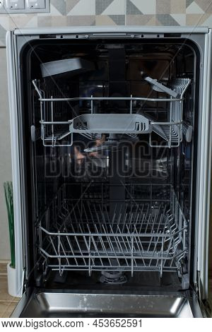 Open Dishwasher. The Hostess Is Preparing To Load Dirty Dishes Into The Dishwasher.