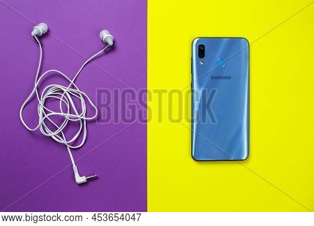Zaporizhzhia, Ukraine - April 22, 2022: Samsung A30 Phone And Headphones.
