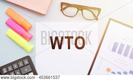 The Text Wto - World Trade Organization, On Office Desk With Calculator, Markers, Glasses And Financ