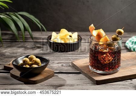 Vermouth Cocktail With Snacks On Wooden Base On Dark Background. Typical Spanish Appetizer.