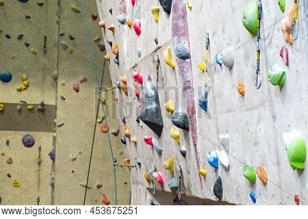 Artificial Rock Climbing Wall With Various Colored Grips.