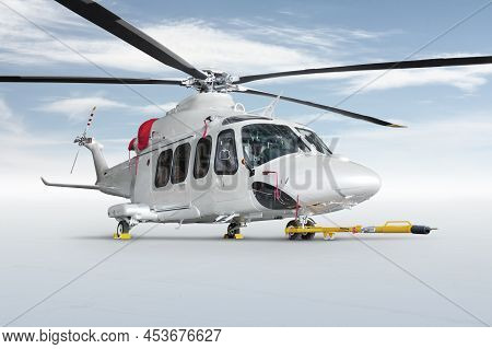 White Luxury Passenger Helicopter With Towbar Isolated On Bright Background With Sky