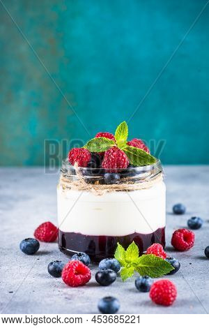 Parfait With Cream Or Yogurt, Jam And Fresh Berries In The Glass Jar. Close Up. Healthy Dessert Or S