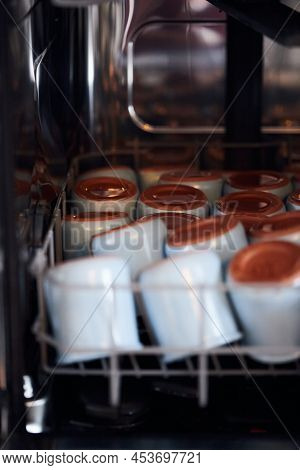 The Process Of Washing Yogrut Jars In The Dishwasher. Homemade Yogurt Making. Vertical Photo.
