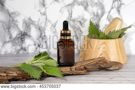 Fresh Nettle In A Wooden Mortar. Preparation Of Elixirs From Medicinal Herbs By Herbalists. The Esse