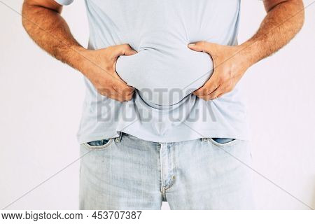 Unrecognizable Man Hlding His Fat Belly In White Background. Studio Shot For Diet And Fitness Concep