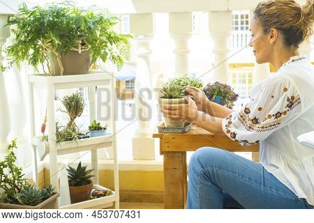 Adult Woman In Gardening Activity Outside Home In The Terrace. Female People Caring Plants For Envir