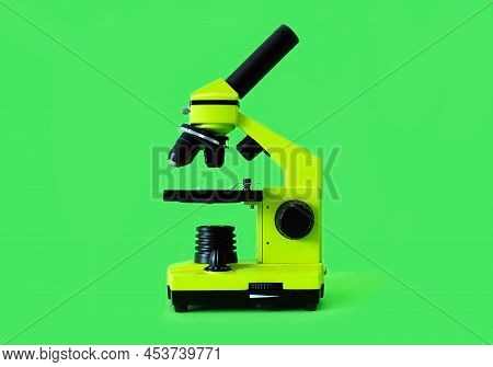 Microscope On A Bright Green Background. High Quality Photo.