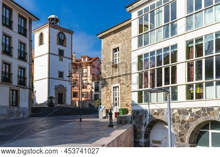 Luanco, Asturias, Spain, May 30, 2021. Clock Tower And Houses In The City Of Luanco, In Asturias