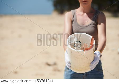 Cropped Image Of Female Vounteer Showing Bucket With Glass Bottles And Plastic Garbage She Found On 