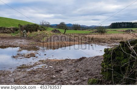 A Breached Flood Bank On A Wetland Restoration Project, With Water Flowing Through Naturally, With S