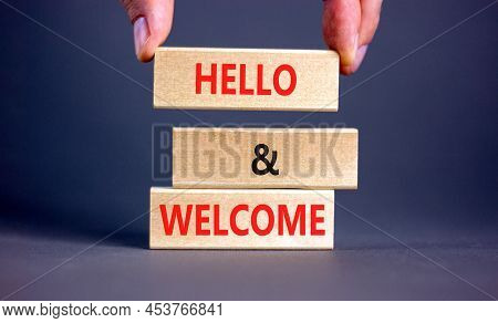 Hello And Welcome Symbol. Concept Words Hello And Welcome On Wooden Blocks. Businessman Hand. Beauti