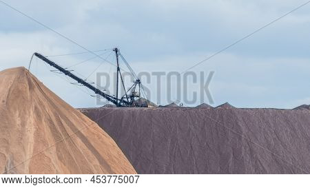 Giant Spreader Or Absetzer Machinery. A Large Dumper On A Landfill With Potash Ore. Extracting And M