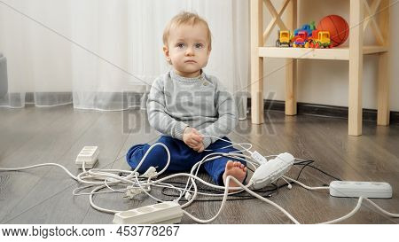Little Baby Boy Playing With Electric Plugs And Wires At Home