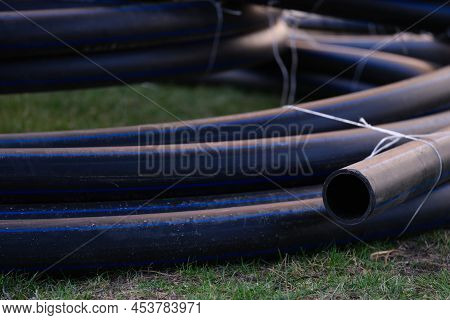 Large Black Plastic Pipes For Water Supply. Pipe For Drinking Water Storage From Hdpe Concept