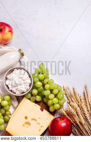 Shavuot Flat Lay With Dairy Products, First Fruits And Wheat On Light Gray Background. Jewish Shavuo