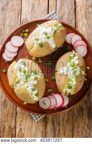 Jacket Potatoes Stuffed With Salted Curd Cheese And Green Onions Close-up In A Plate On A Wooden Tab