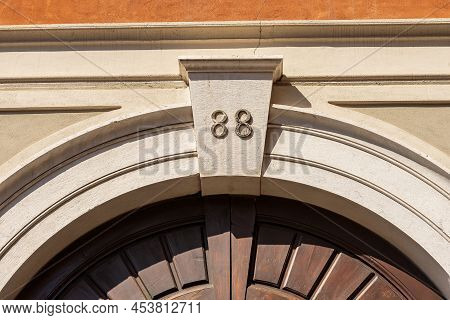 Close-up Of An Ancient Marble Arch With Keystone, Wooden Door And The House Number Eighty Eight (88)