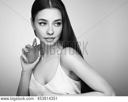 Young Beautiful Woman With A Bottle Of Perfume. Model With Healthy Skin, Close Up Portrait. Cosmetol