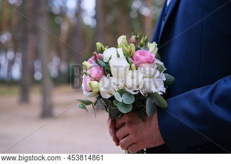 Man Hand Holding Flowers. Bouquet Of Flowers For Congratulations.