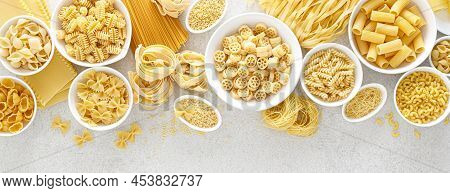 Pasta. Various Kinds Of Uncooked Pasta And Noodles Over Stone Background, Top View With Copy Space F